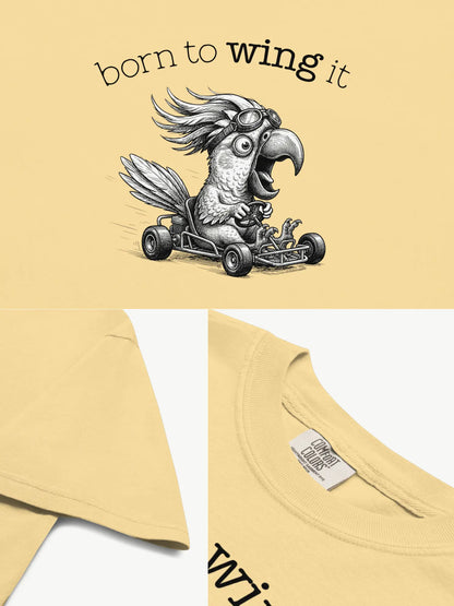 Close-up details of the Born to Wing It cockatoo t-shirt in butter showing print texture, folded view, and collar