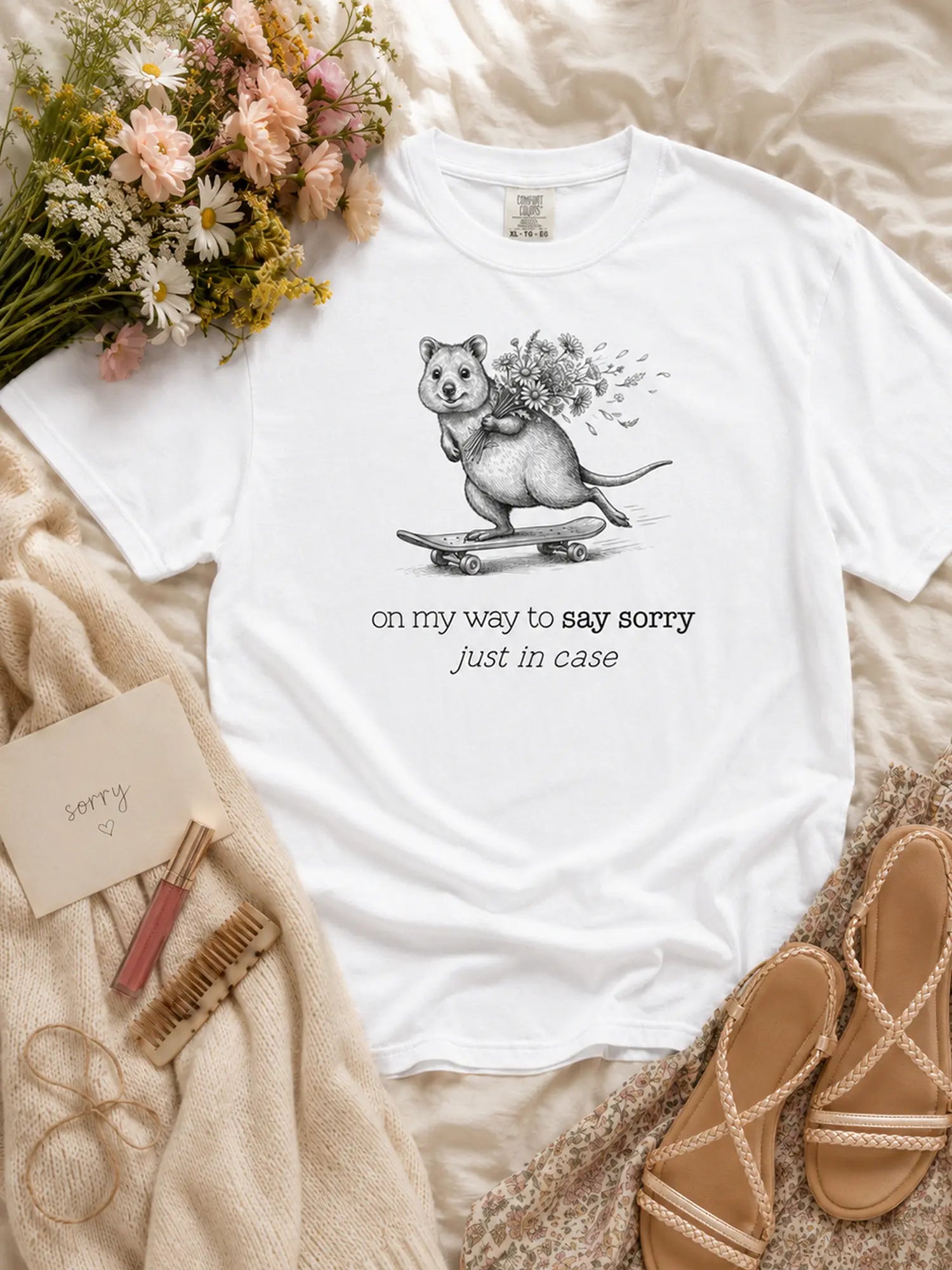 The Sorry Quokka t-shirt in white styled flat lay
