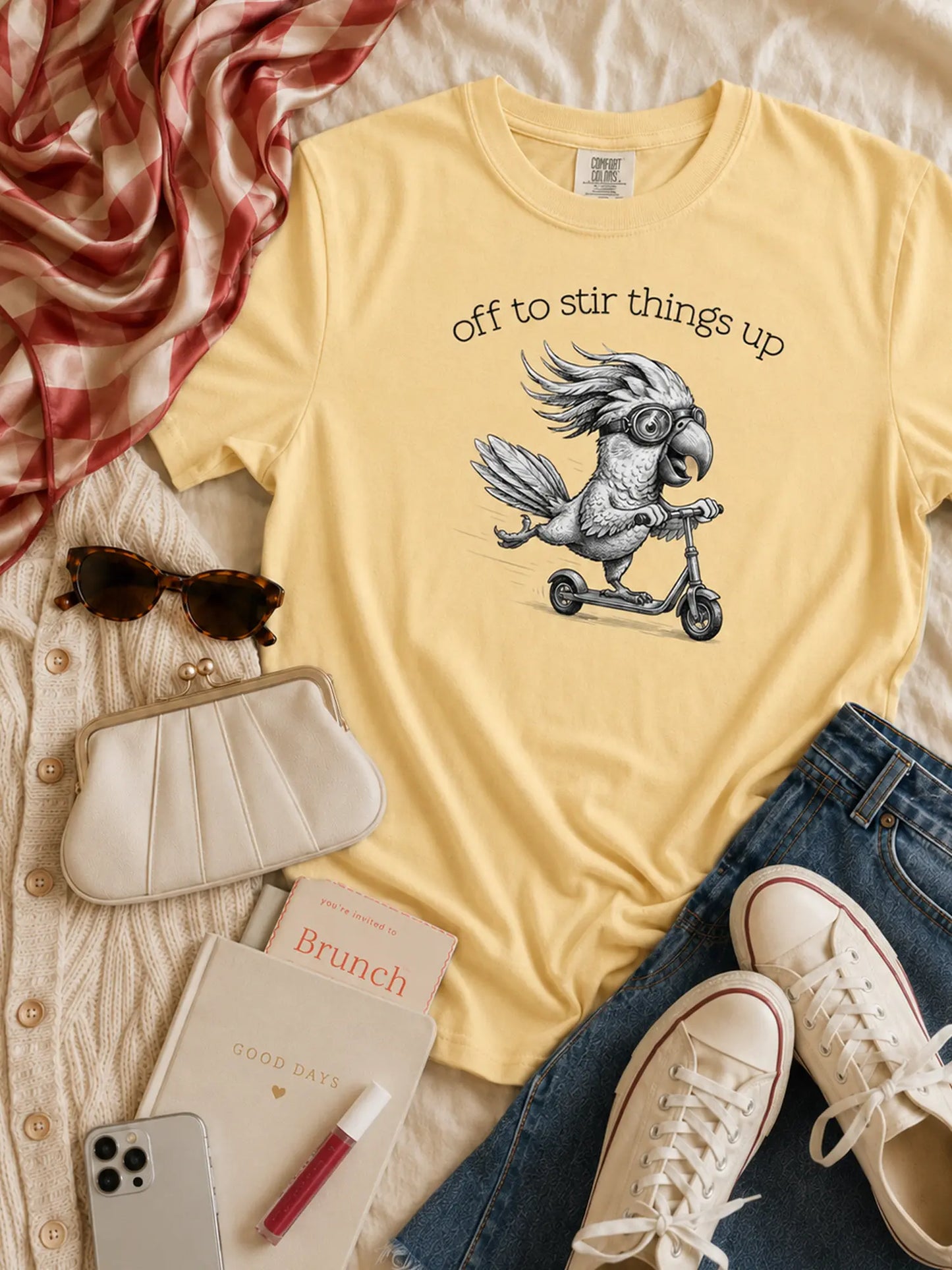 Off to Stir Things Up cockatoo t-shirt in butter styled flat lay